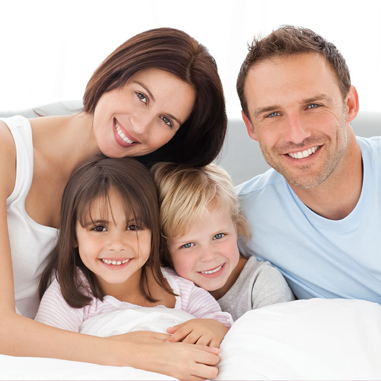 Happy family smiling together after family dental care at the Concord practice